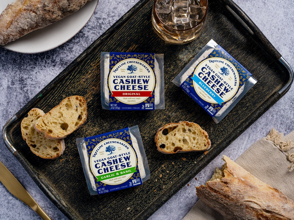 all 3 Treeline Vegan Goat-Style cheeses on a tray with some crusty bread