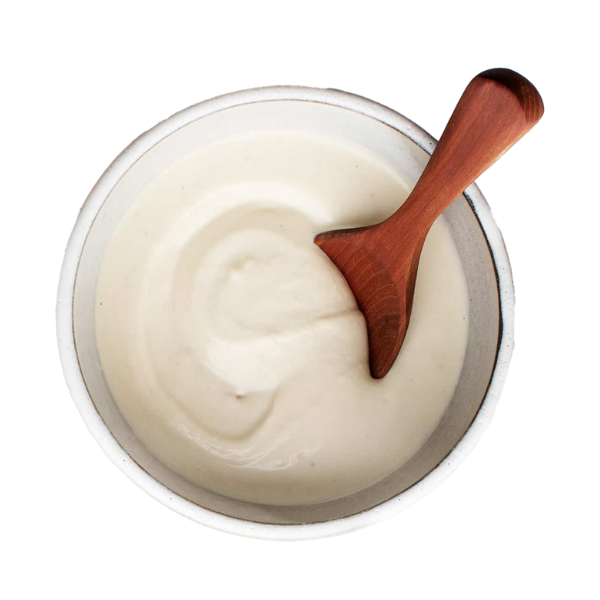 a bowl of cashew cream with a wooden spoon