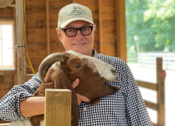 a photo of Treeline Cheese founder with a goat