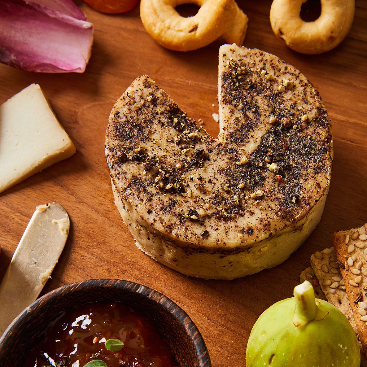 a photo of a pepper encrusted cheese wheel